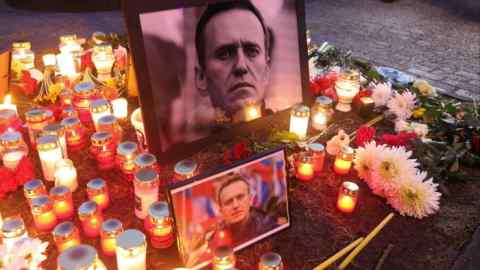 Candles surround photographs during a vigil for Russian opposition leader Alexei Navalny, outside the Russian Embassy in Riga, Latvia